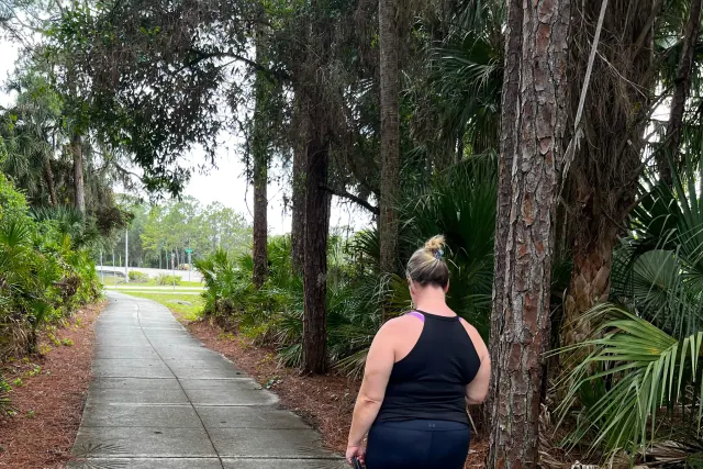 Owner walking her dog on a loose leash along a North Port sidewalk